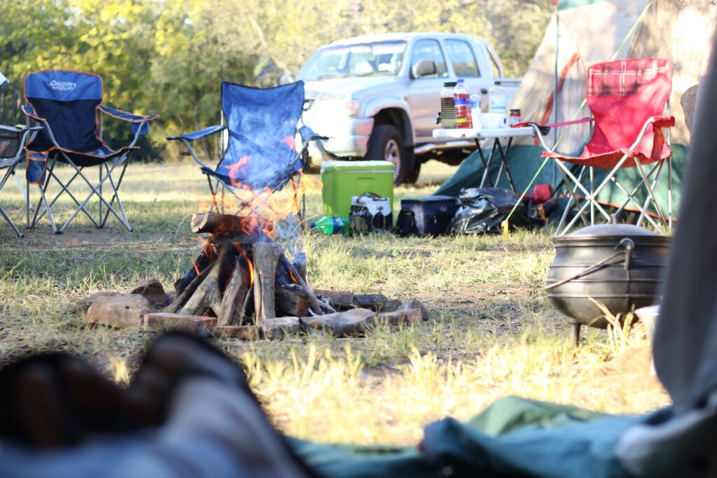 Fun, Mobile Camping Chairs In Front Of Bonfire Near Pickup Truck